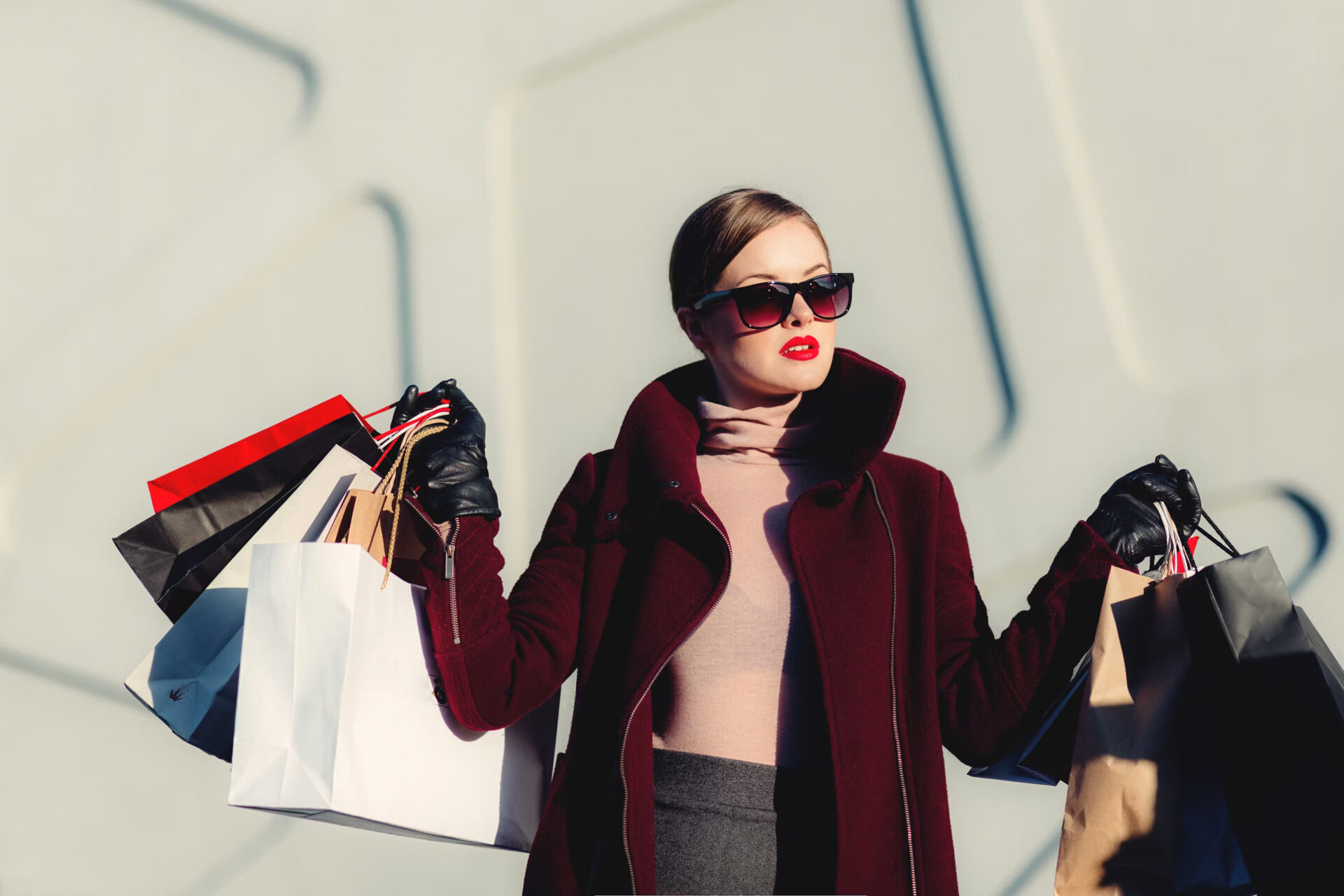 Office Style Diary - Stylish woman in burgundy coat and sunglasses carrying multiple shopping bags, fashion-forward shopper, luxury retail therapy, urban chic look with red lipstick