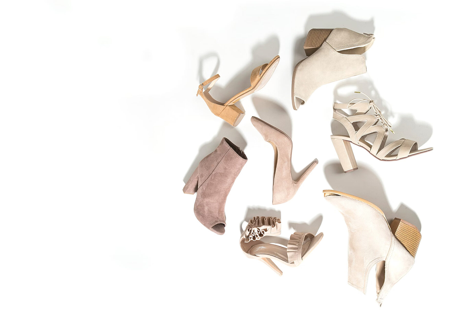 Office Style Diary - Various styles of beige and taupe women's high heels and ankle boots on a white background.